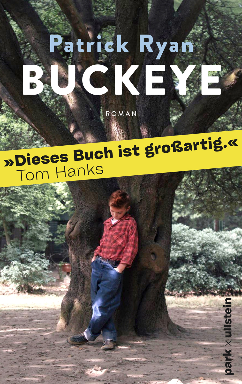 Cover von Buckeye von Patrick Ryan: Ein Junge in rotem Karohemd und blauen Jeans lehnt vor einem großen Baum, Parkkulisse.